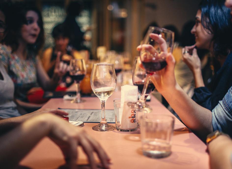 people drinking liquor and talking on dining table close up photo